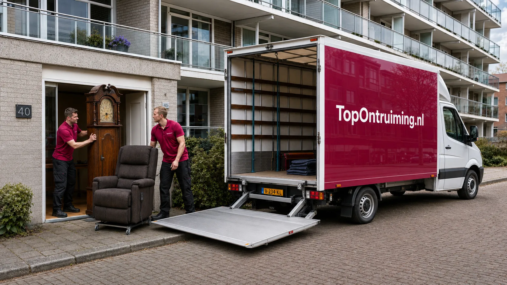 Medewerkers van TopOntruiming.nl laden een staande klok en fauteuil in de vrachtwagen bij een appartementencomplex